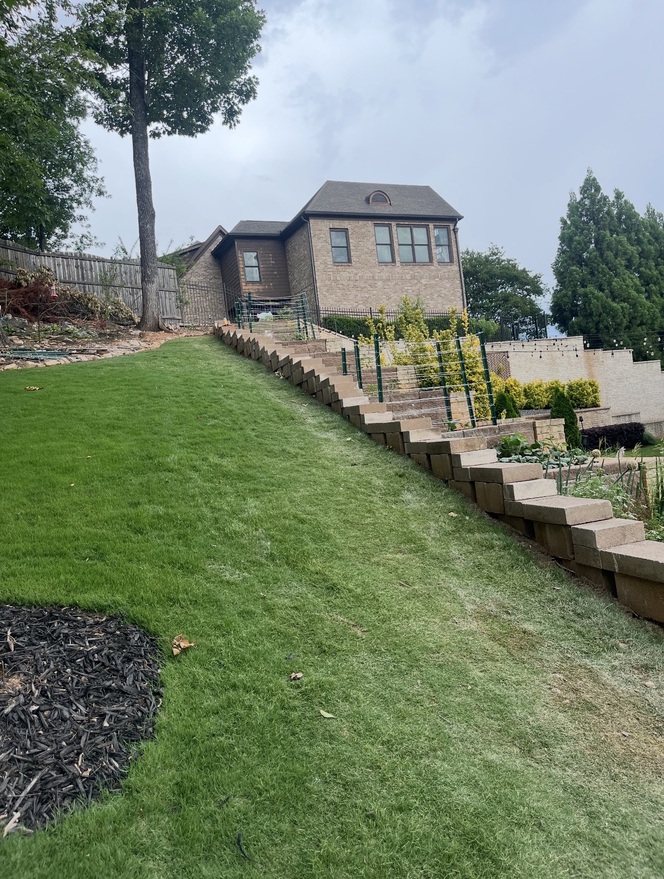 Tall block retaining wall with tiered steps